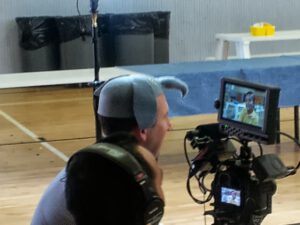 Brian Greenberg dons an elephant hat while interviewing a student at KIPP LA. Photo by Michael Horn.