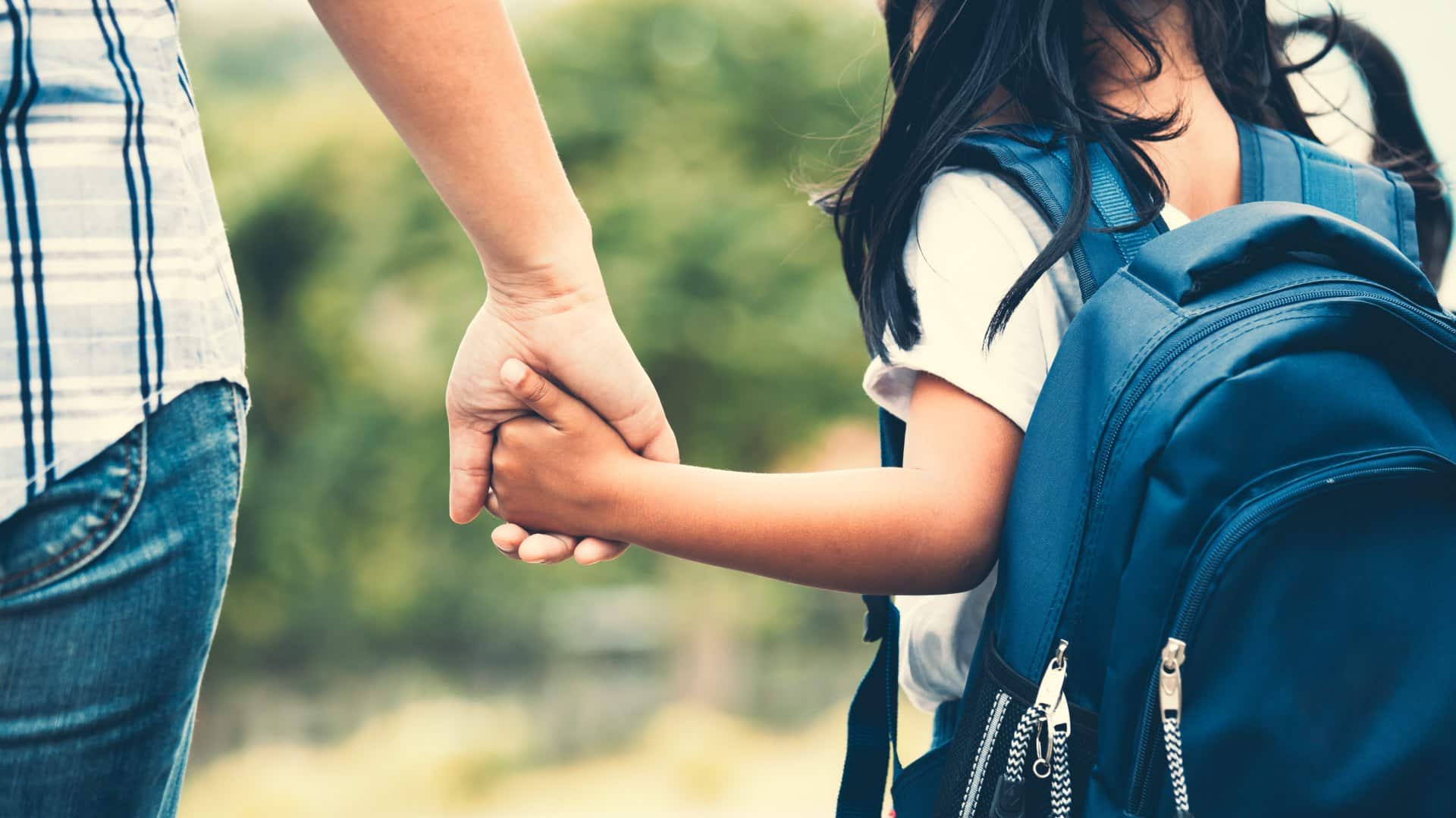 parent and child holding hands and going to school